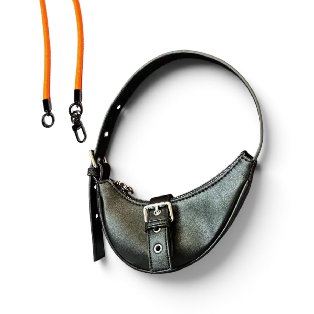 A crescent-shaped black leather shoulder bag with a buckle strap detail, shown on a white background with an orange detachable shoulder strap.