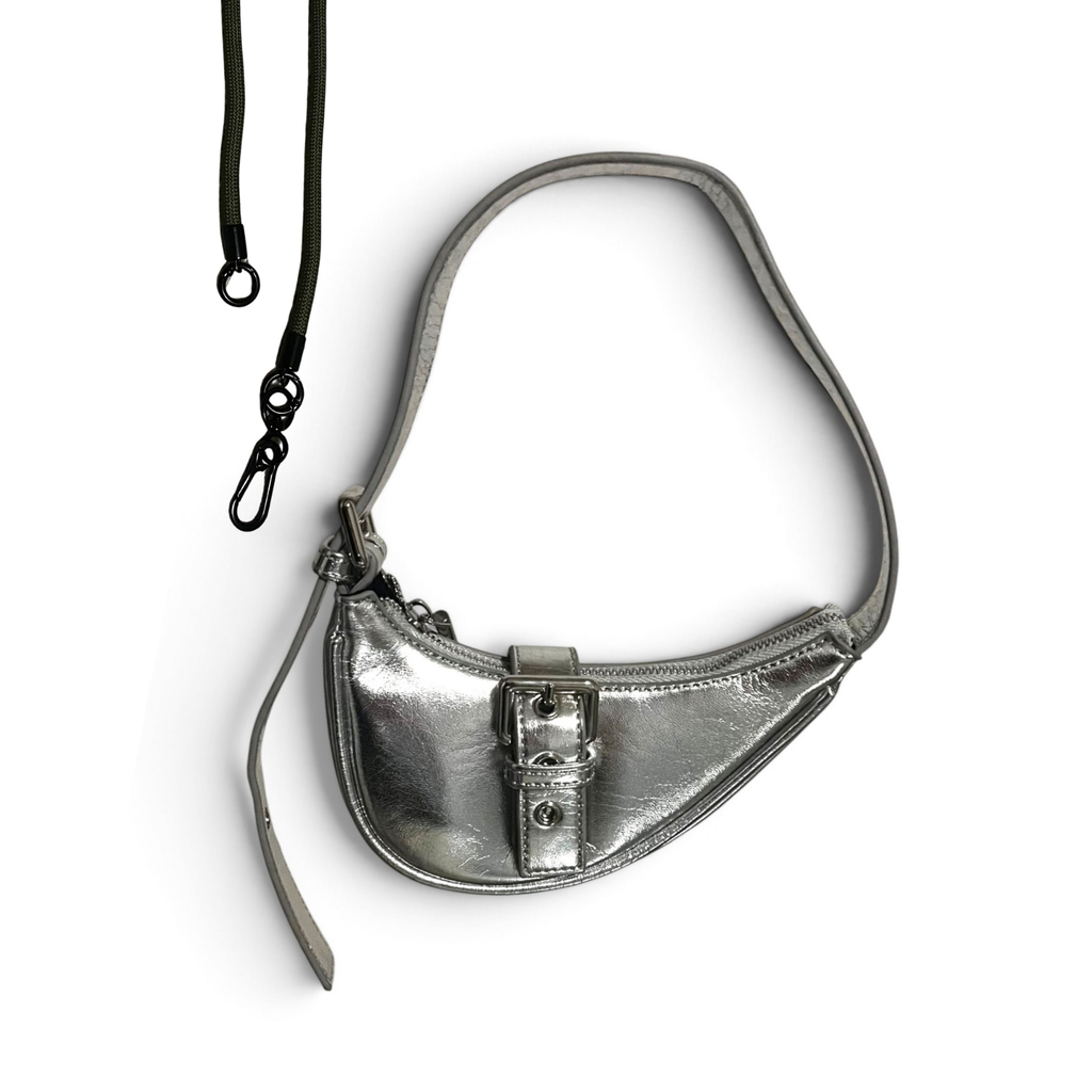 A metallic silver crescent-shaped shoulder bag with a black adjustable strap and a front buckle detail, shown on a plain white background.