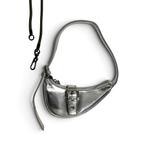A metallic silver crescent-shaped shoulder bag with a black adjustable strap and a front buckle detail, shown on a plain white background.