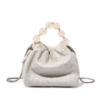 White bone colour textured small handbag with beaded handle on a white background