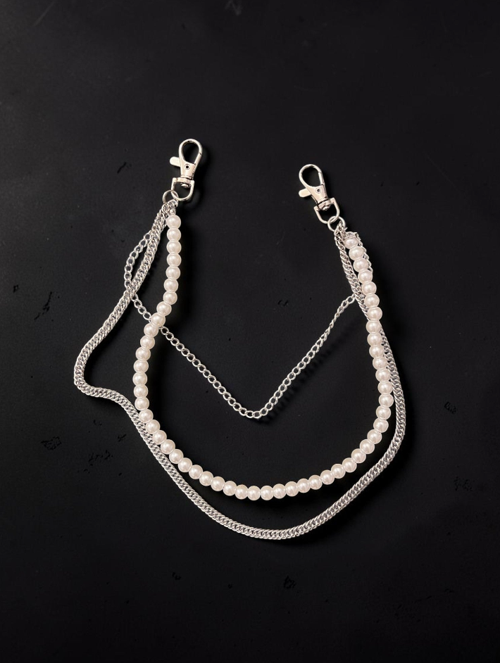 A double-layered necklace featuring a strand of white faux pearls and silver-tone chains, including a curb chain and a textured beaded chain, with lobster clasp closures at the top, displayed on a dark background.