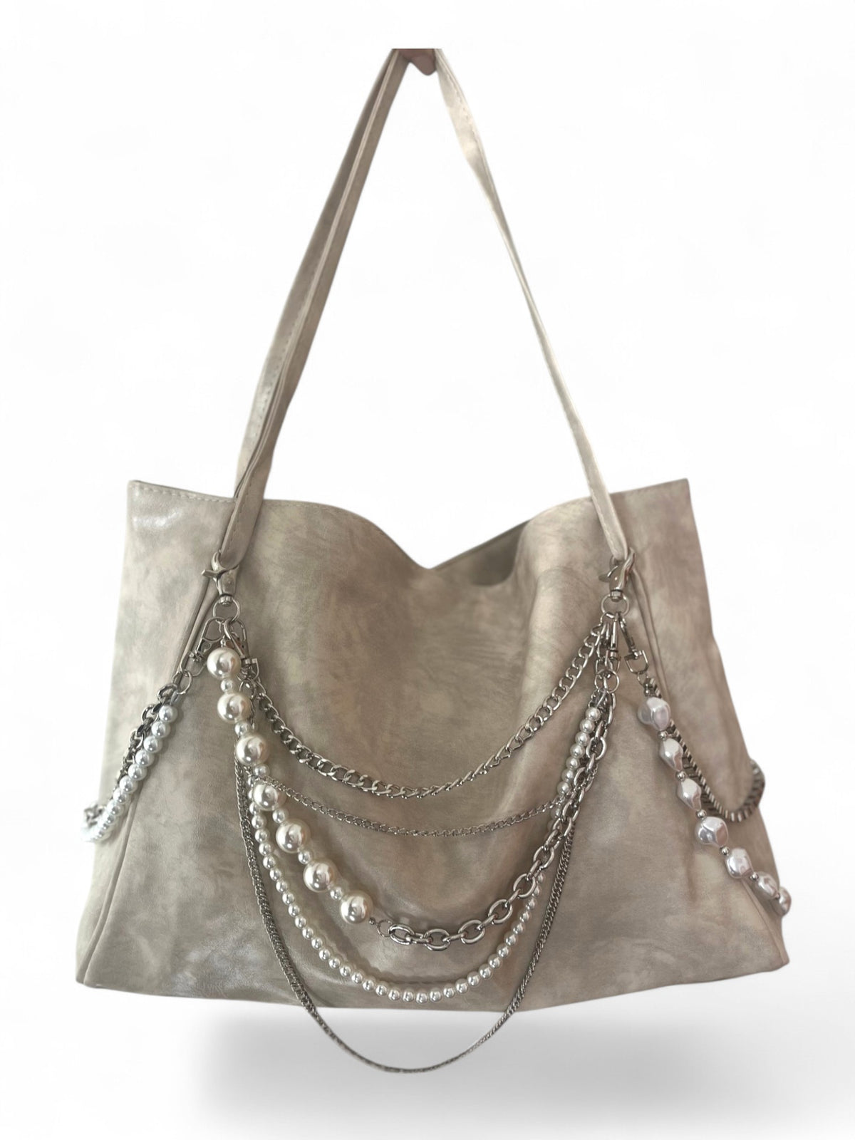 A taupe faux-leather tote bag adorned with multiple draped silver chains and strands of white faux pearls, shown against a plain white background.