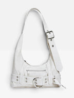 White vegan leather shoulder bag with a chunky eyelet belt, oversized silver buckle and buckled strap on a white background